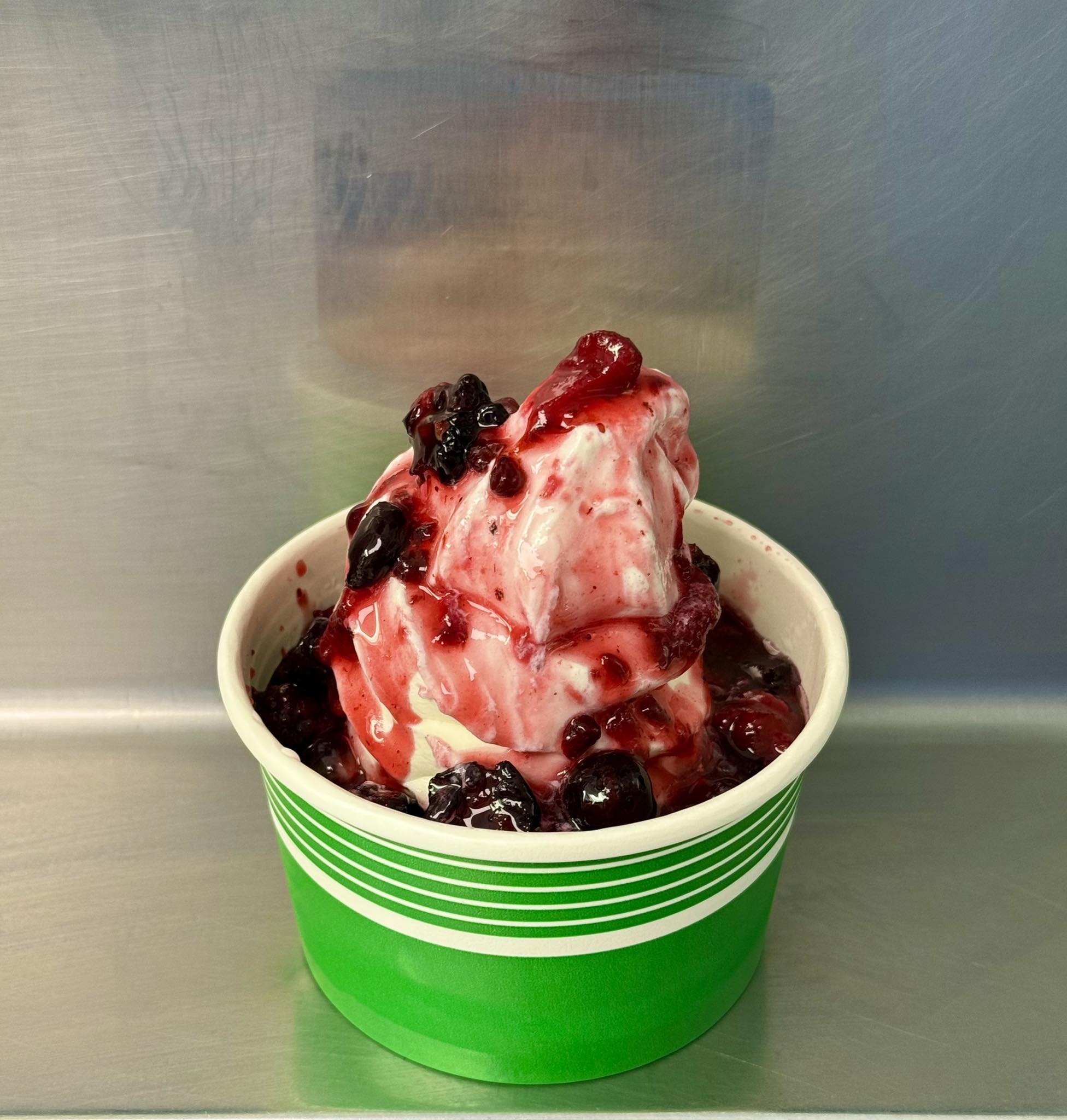 Dairy Haven soft serve covered in berry topping, served in a green cup
