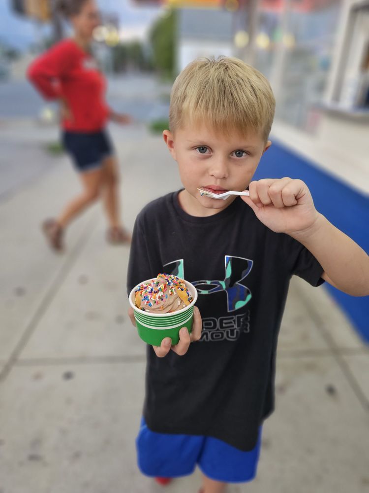 A child enjoying a sprinkle-covered cup of ice cream at Dairy Haven